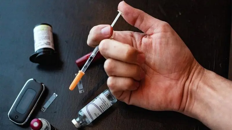 A hand holding an injection of medication for diabetes