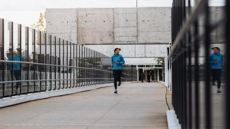 Female jogs on bridge outdoors