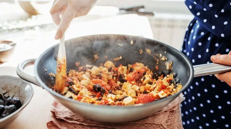 Tofu and vegetables cooking in a skillet