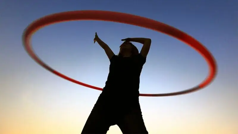 Silhouette of a female with a hula hoop