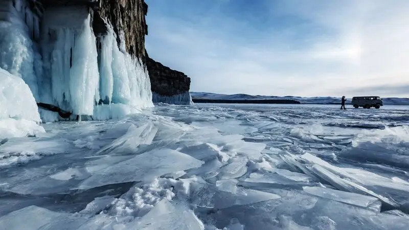 photo of permafrost with minivan and human silhouette in the background