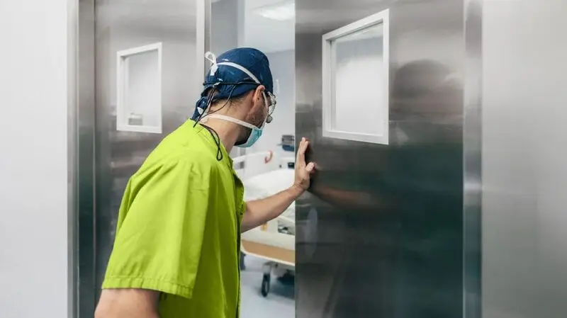 A surgeon enters an operating room