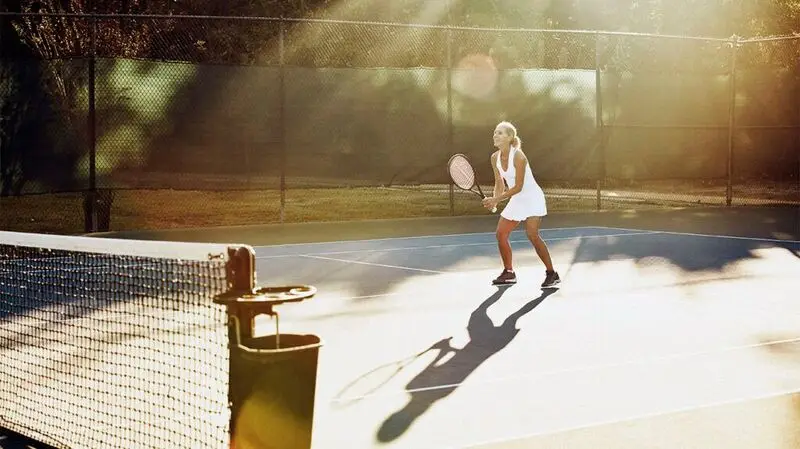 A middle-aged woman plays tennis