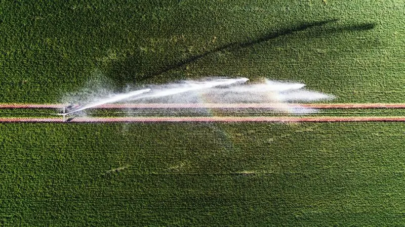 bird's eye view photo of sprinkler over green lawn