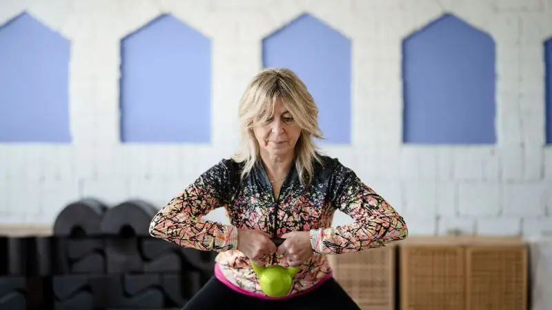 older woman lifting weight at the gym