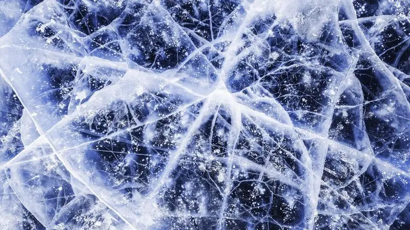 Close up of ice cracks in a frozen surface