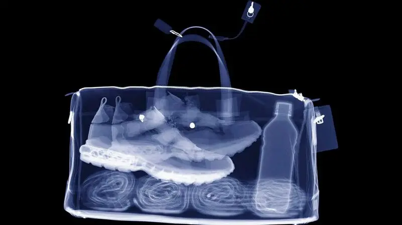 x-ray of gym bag containing towels, sports shoes, and bottle
