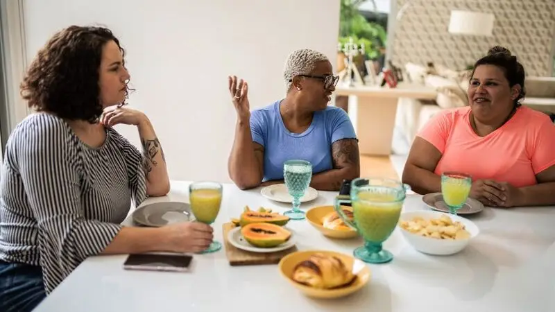 Three female friends eating breakfast at a table