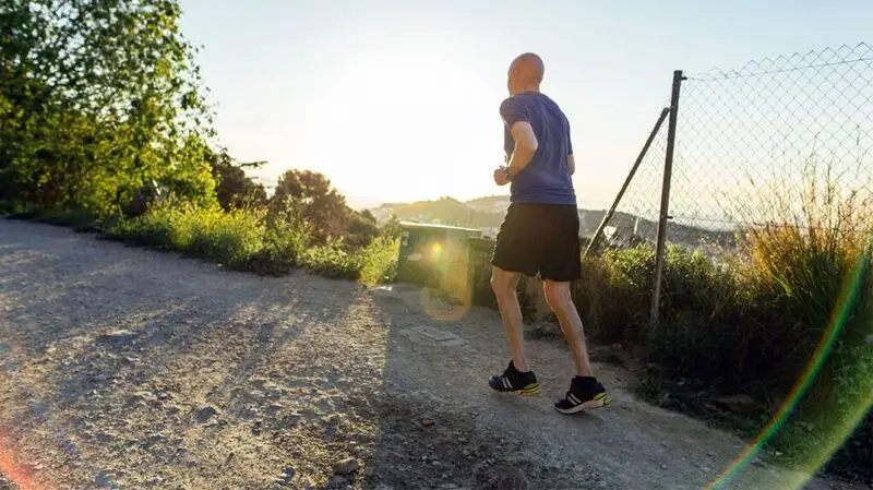 A man running outdoors on a sunny day