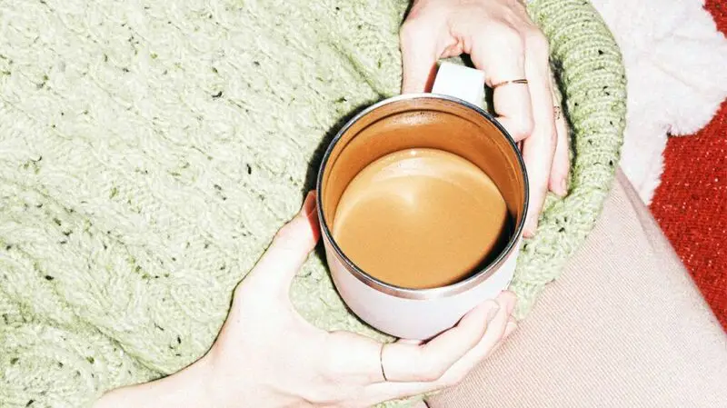 A person holding a a cup of coffee