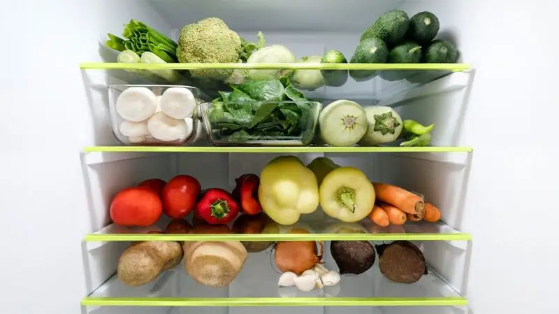 fridge shelves stocked with an assortment of vegetables