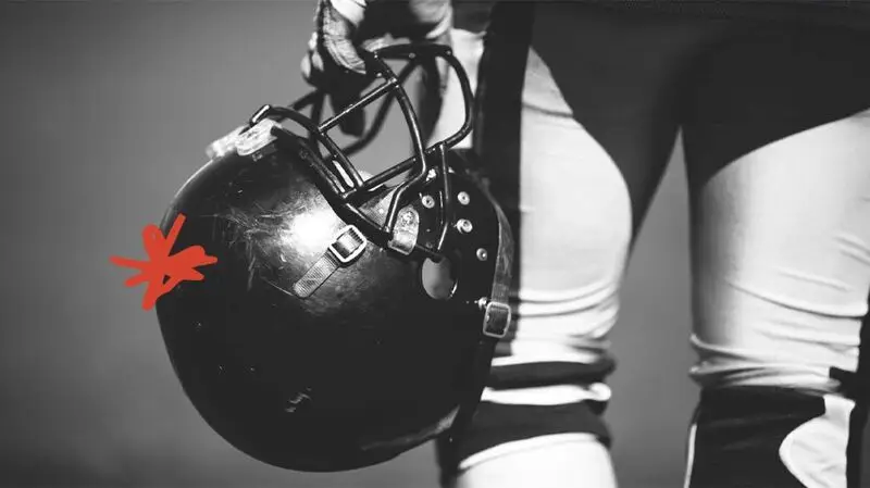 American football player holding a helmet