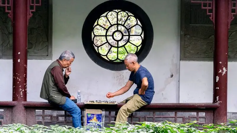 Two older males play checkers