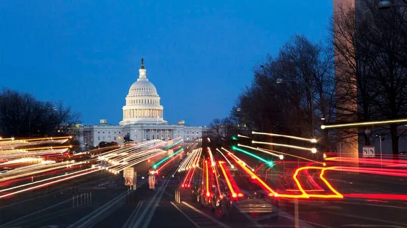 the United States Capitol building at night, traffic lights creating lines with a long exposure shot