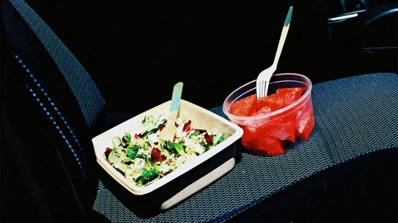 container with salad next to bowl of watermelon slices