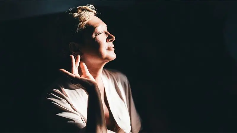 older white woman in profile against a dark background