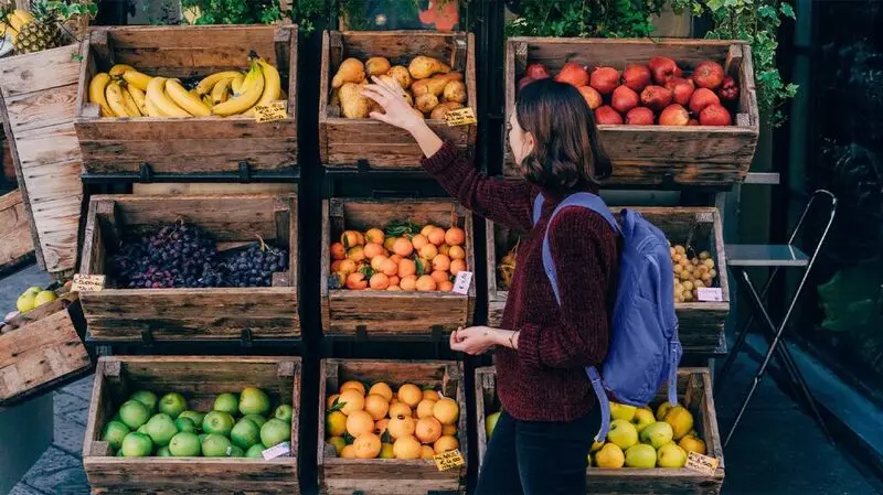 young person browsing fruit stall