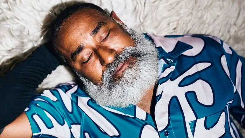 middle-aged Black man with white beard pictured sleeping