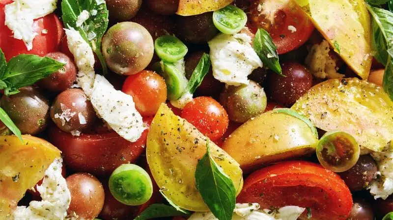 close-up of salad with tomatoes, basil, and feta