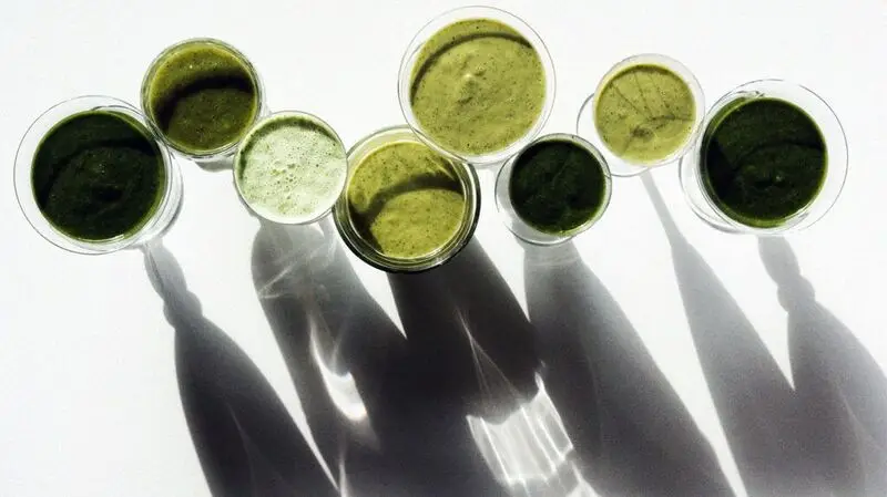 eight green smoothies seen from above