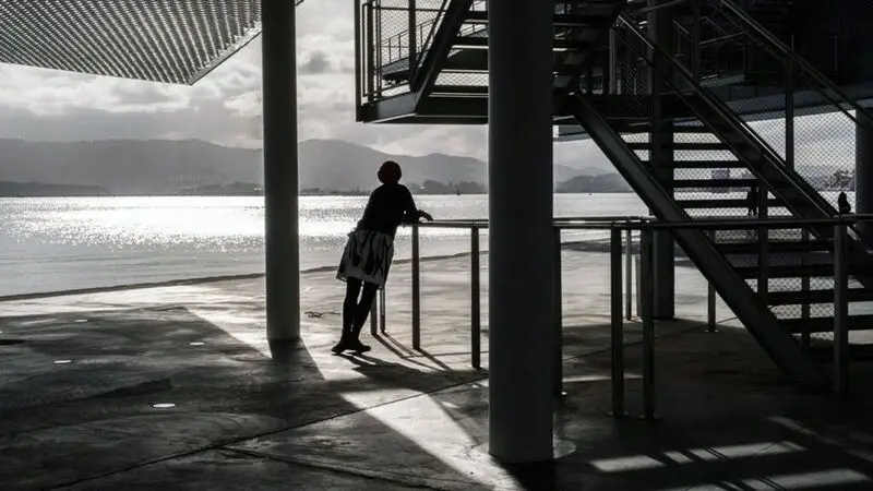 black and white photo of female silhouette by an outdoor staircase