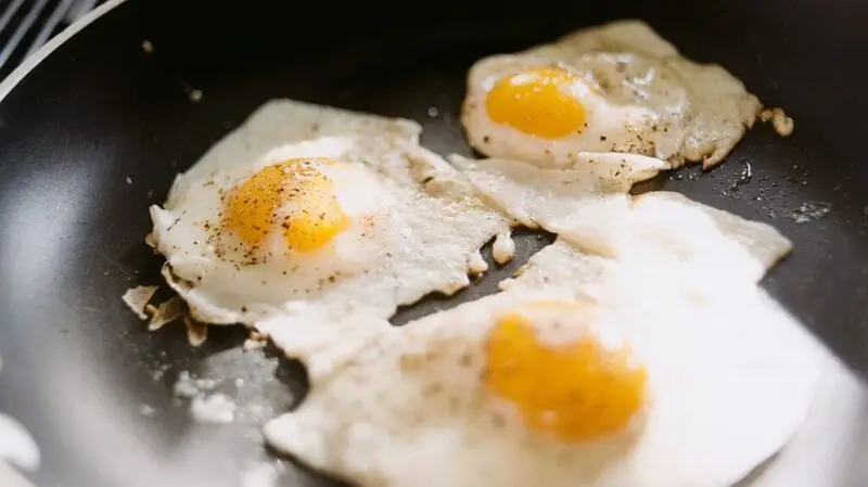 Three fried eggs in a pan 