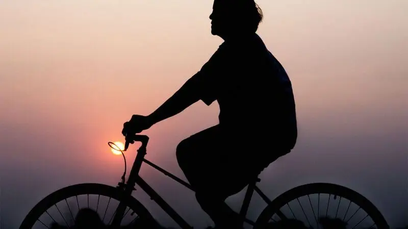 A person riding a bike at sunset
