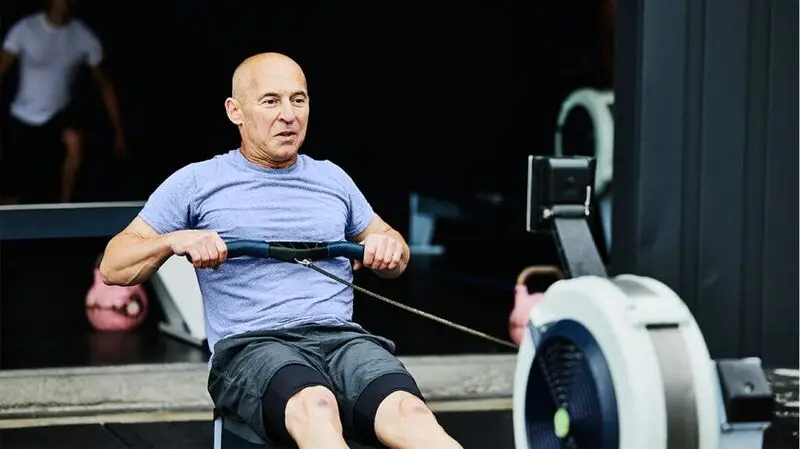 middle-aged white man undergoing strength training at the gym