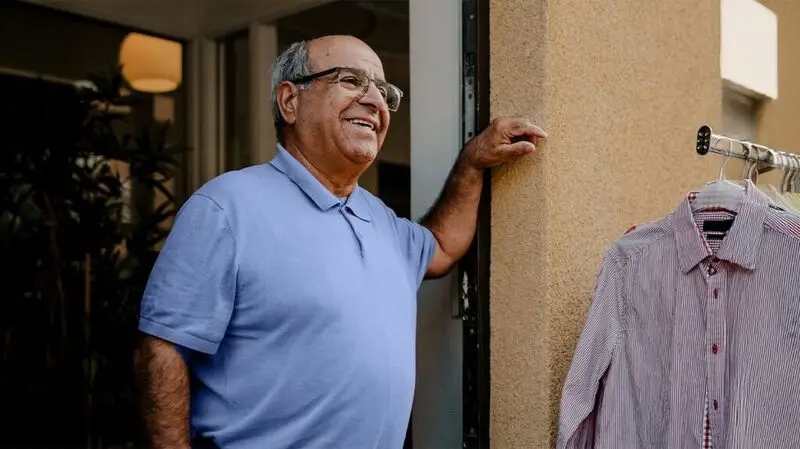 smiling older man standing in doorway