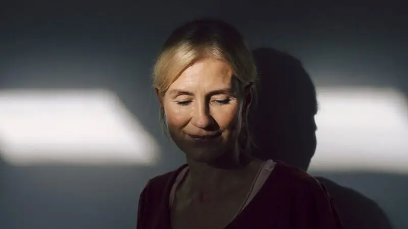 middle-aged white woman pictured in half-shadow