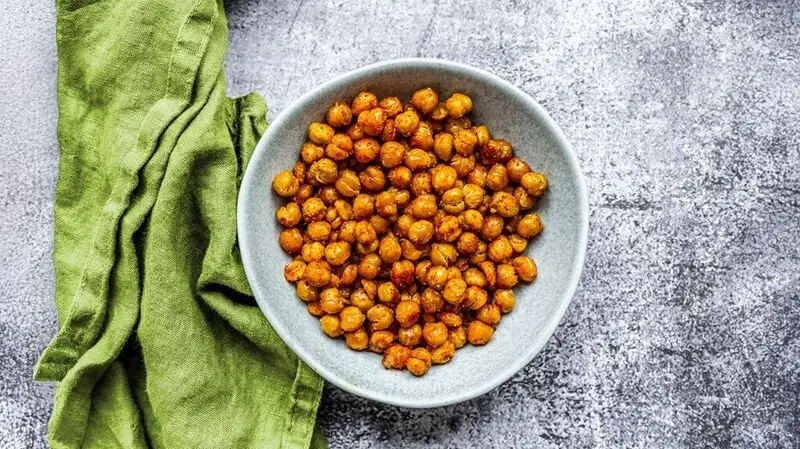 A bowl of chickpeas from above, a tea towel on the side