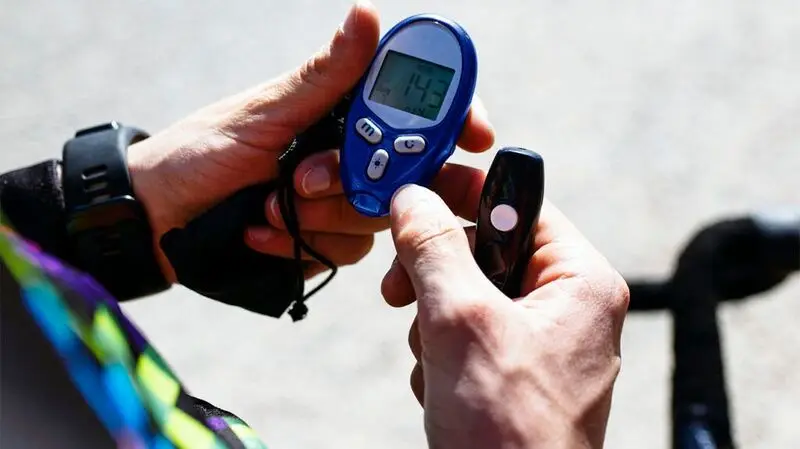 A person with diabetes holding an insulin monitor in their hands