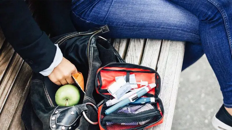 person's hand rummaging through bag next to GLP-1 drug pouch