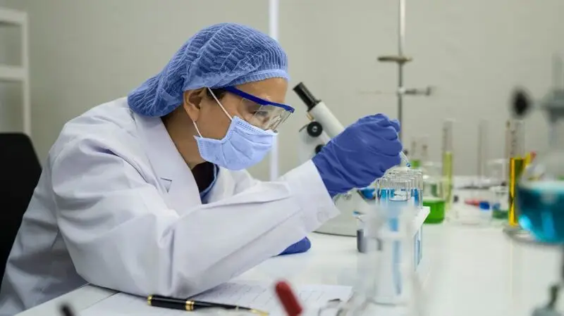 masked researcher with test tubes in lab