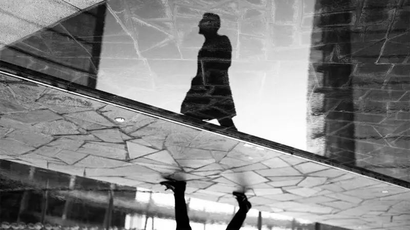 shadowy reflection of person walking