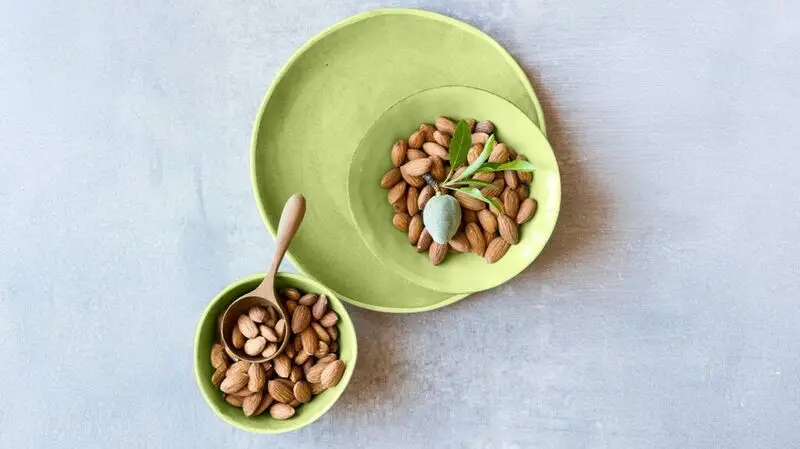 almonds in green bowl and on green plate