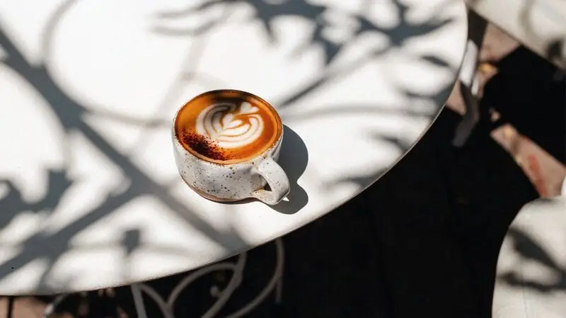 A cappuccino in a ceramic mug on a white table