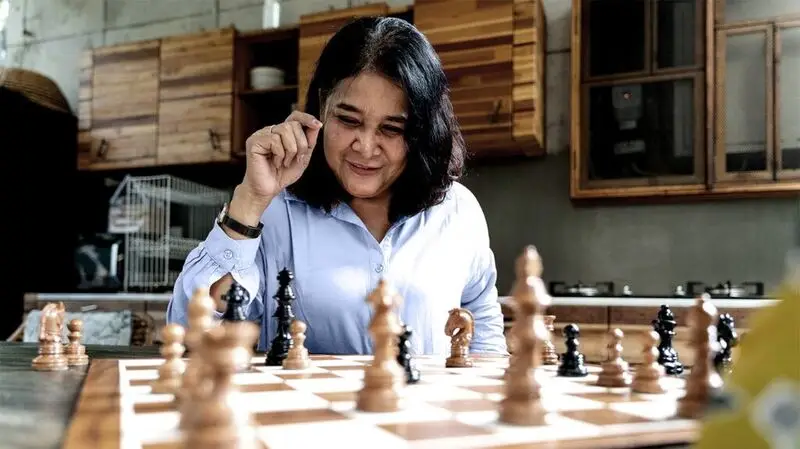 A woman in her menopausal years playing chess