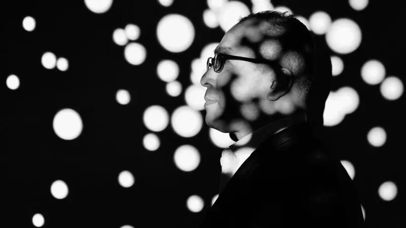 The side profile of a man as lights shine on him in polka dot form