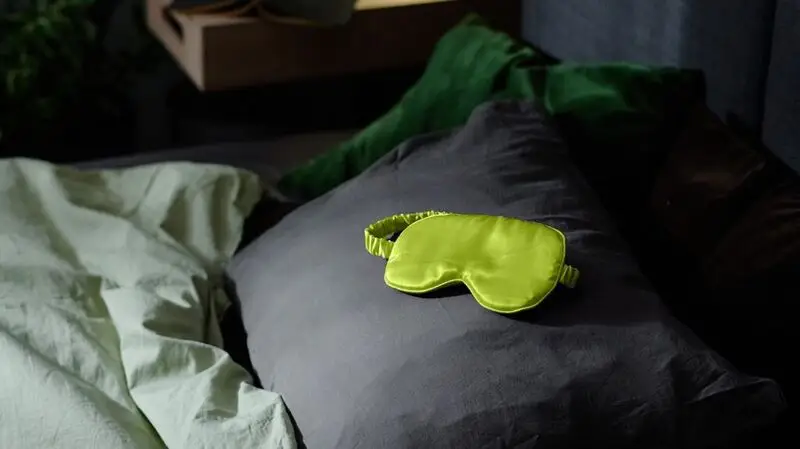 green sleep mask on gray pillow
