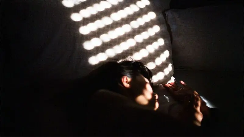 person pictured sleeping in semi-darkness