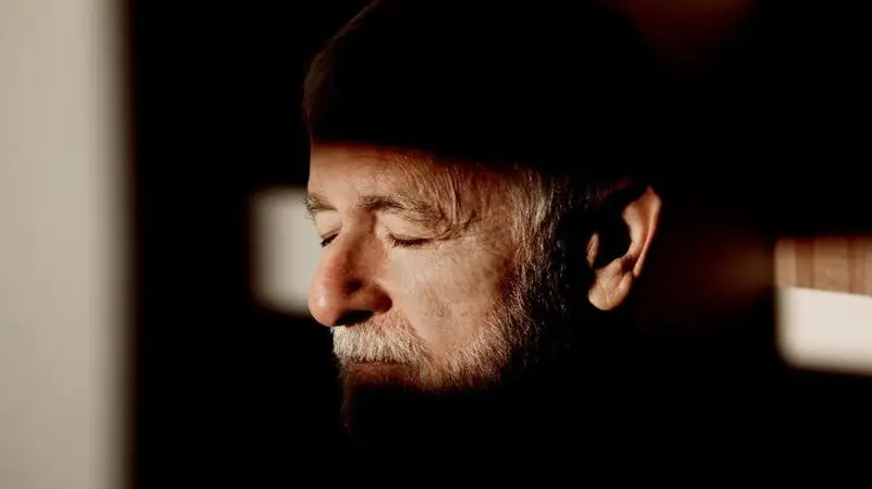 A man closes his eyes as the sun shines on his midface