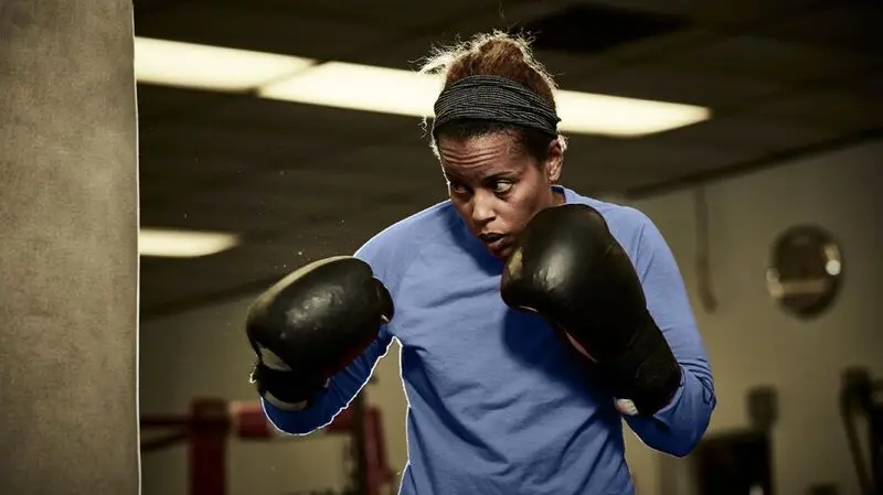 A person boxing with boxing gloves at a gym