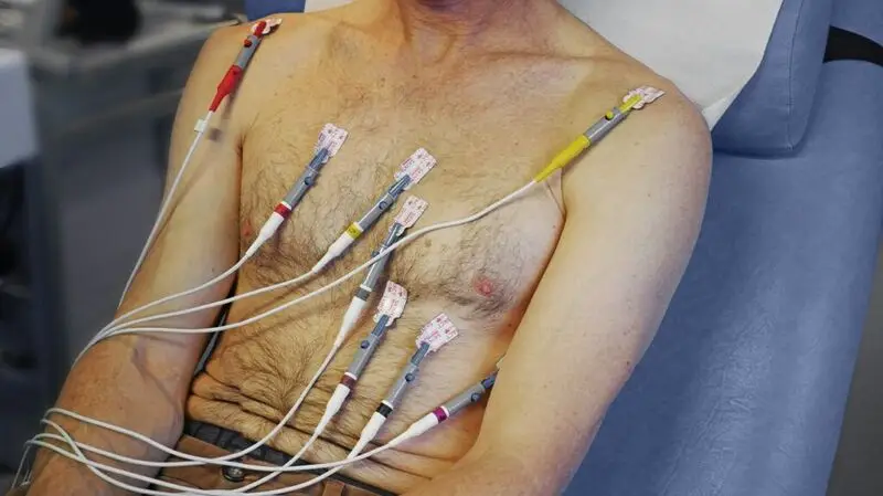 A man undergoes a check up for heart health as many electrodes are attached to his chest