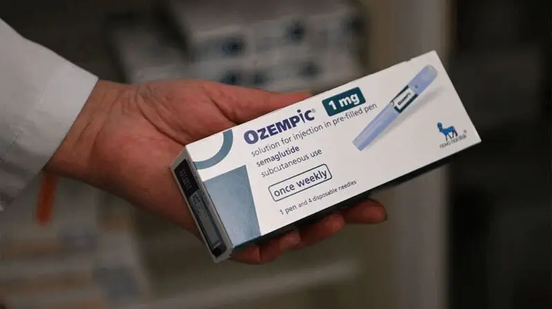 hand holding Ozempic package