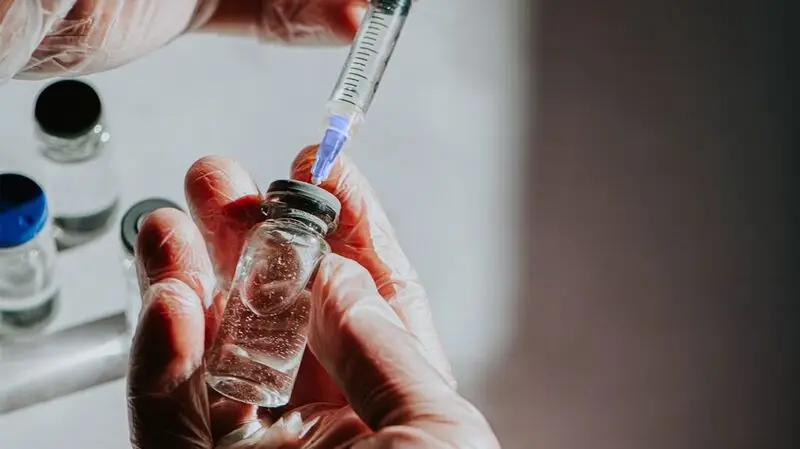 A person getting an injection with the weight loss drug eloralintide ready by extracting a dose from the vial