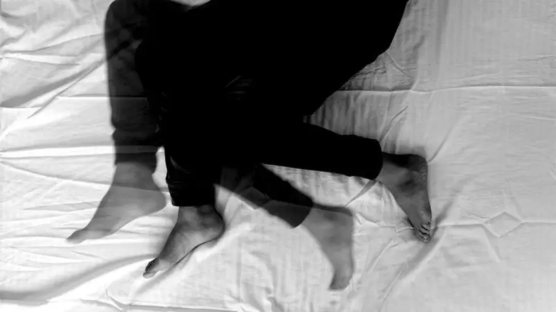 multiple exposure black and white photo, suggesting moving legs in a bed