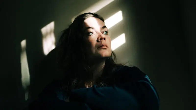 white woman looking up pensively