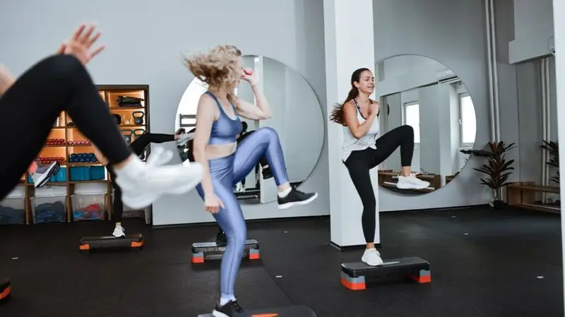 A group of women doing a high intensity interval training style workout in a studio 