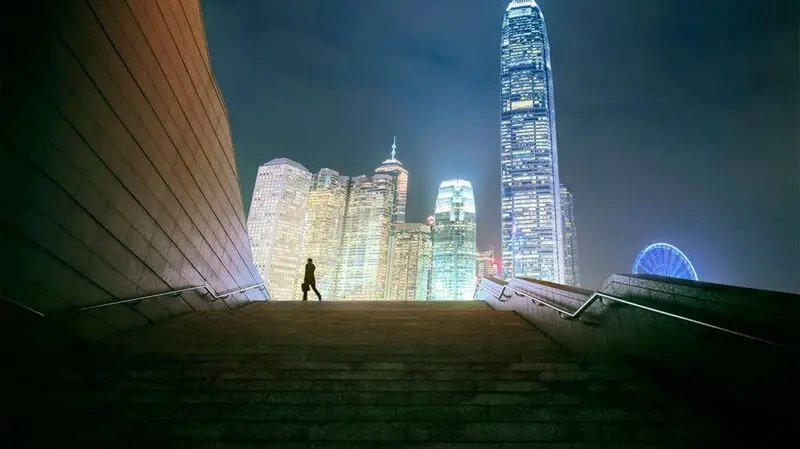 human silhouette moving against bright city skyline at night